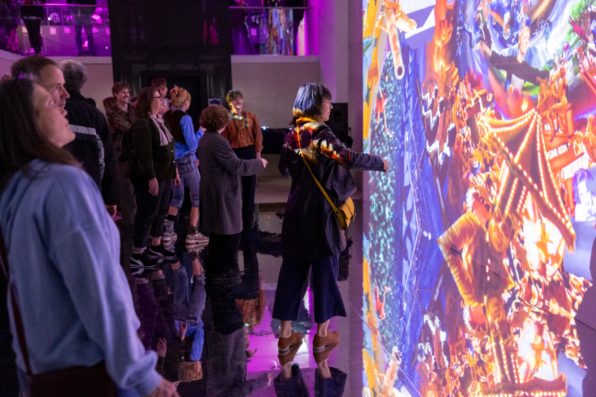 Besucher*innen vor einer bunten Videoarbeit.