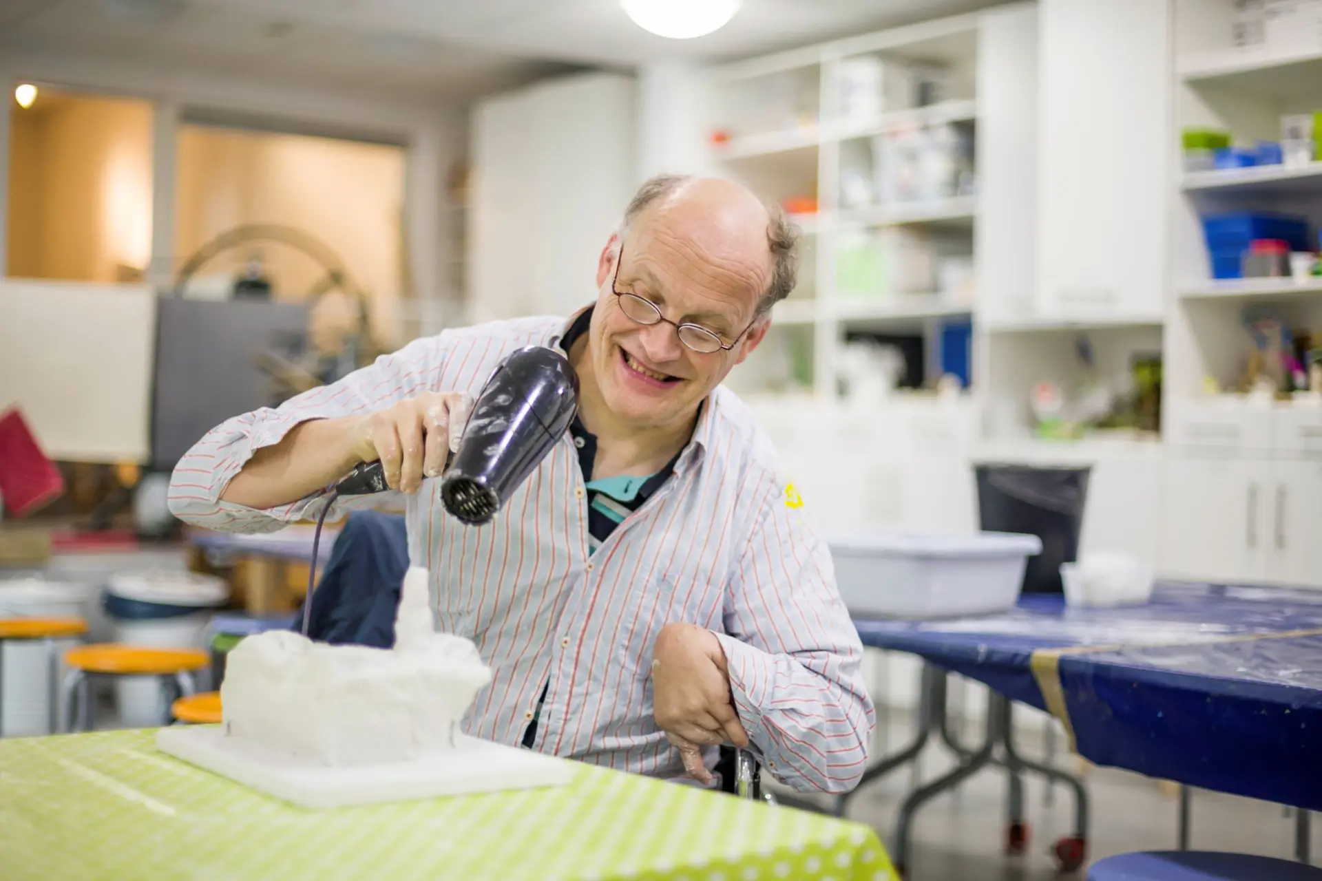 Ein Mann föhnt eine Skulptur in der Museumswerkstatt
