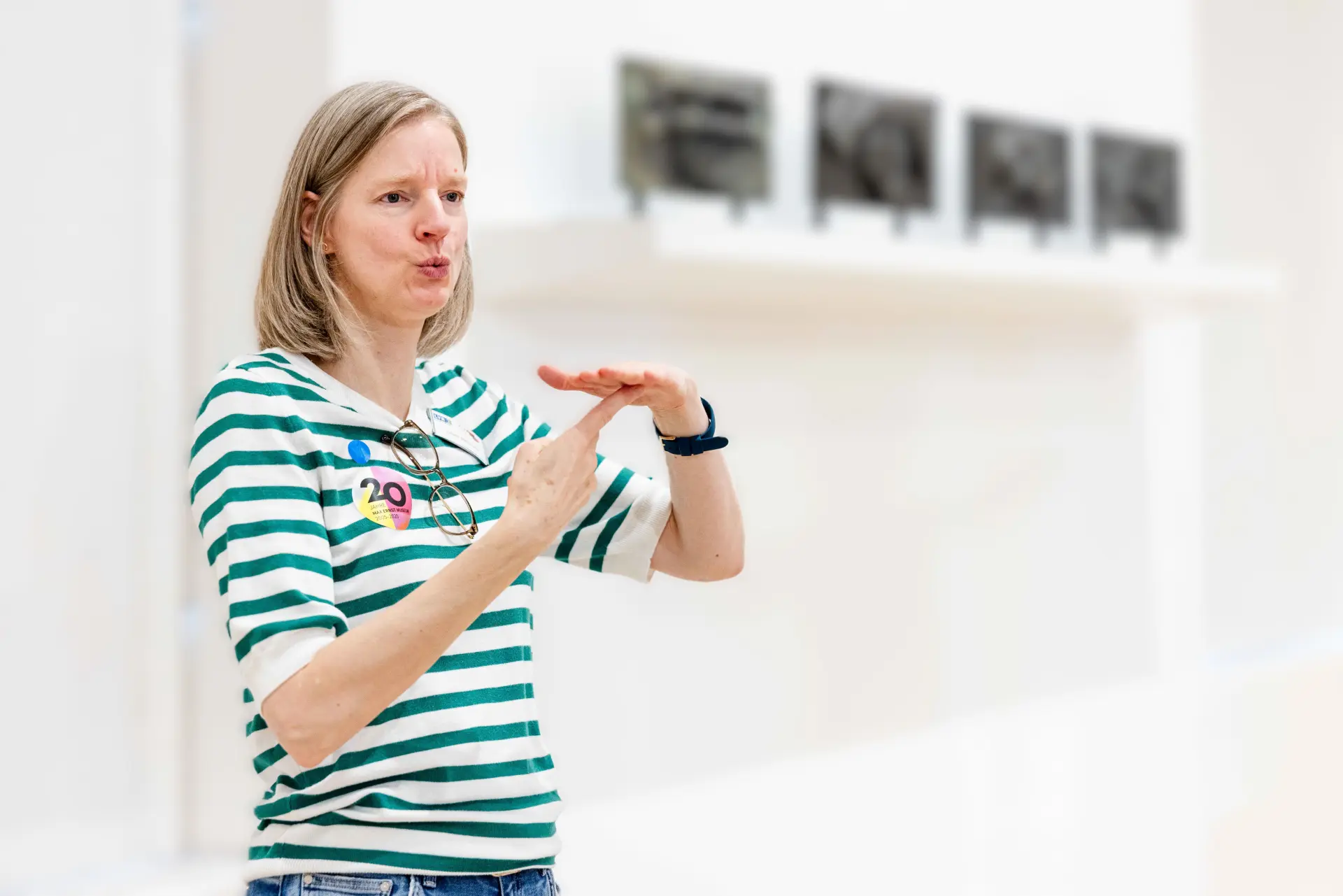Eine Frau erklärt in Gebärdensprache Besuchern etwas 