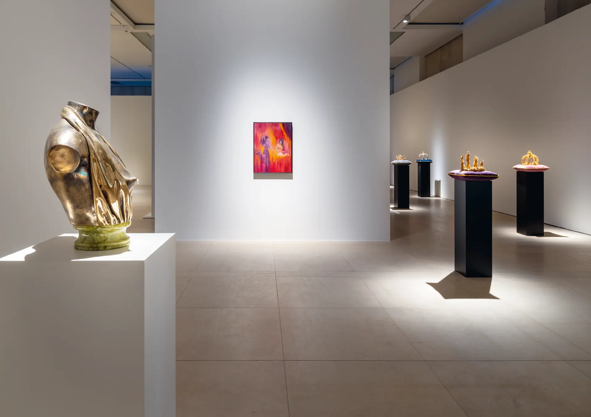 Ausstellungsansicht mit einer goldenen Büste links und einem Gemälde in der Mitte des Raumes