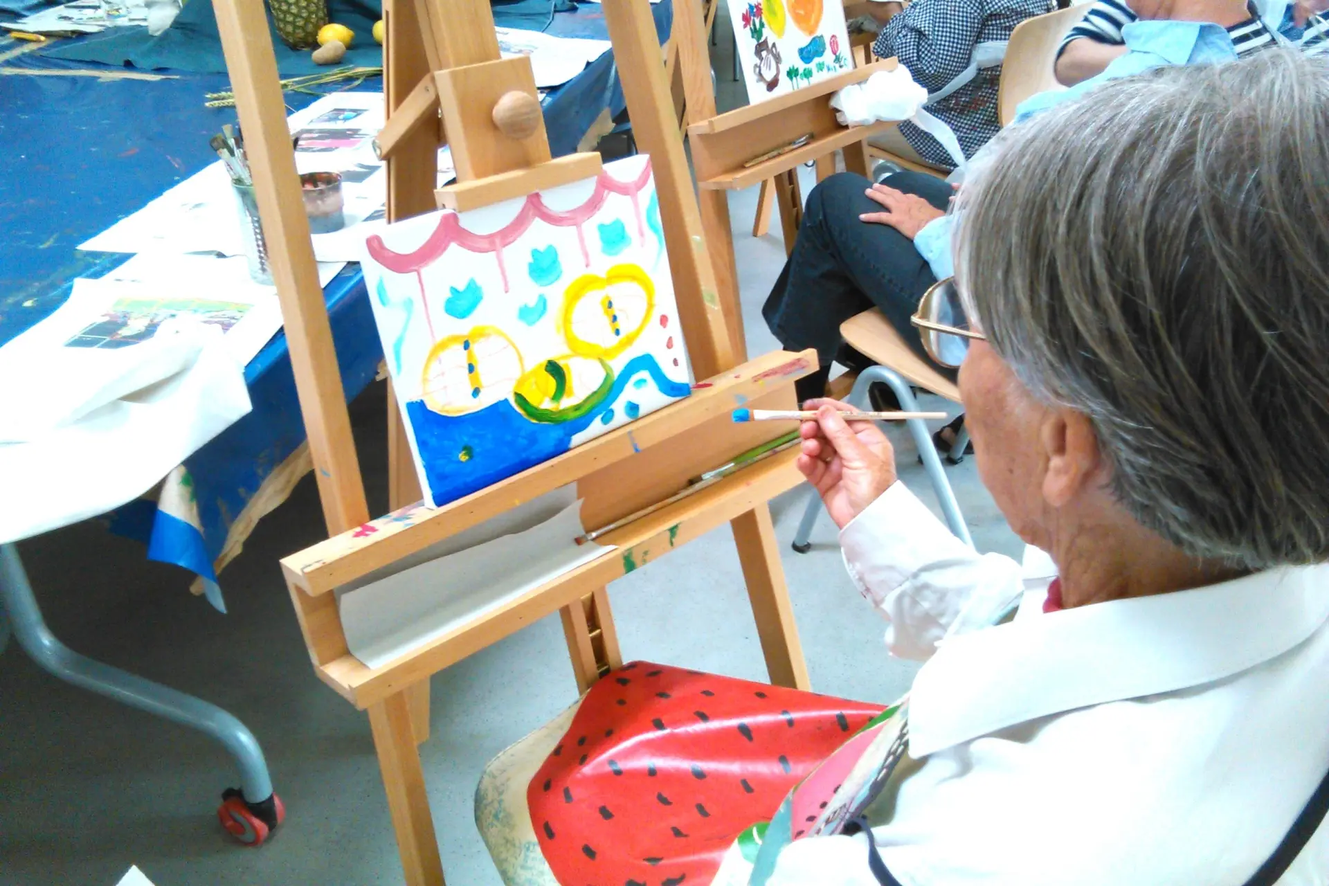 Drei ältere Frauen bearbeiten Kunstwerke.