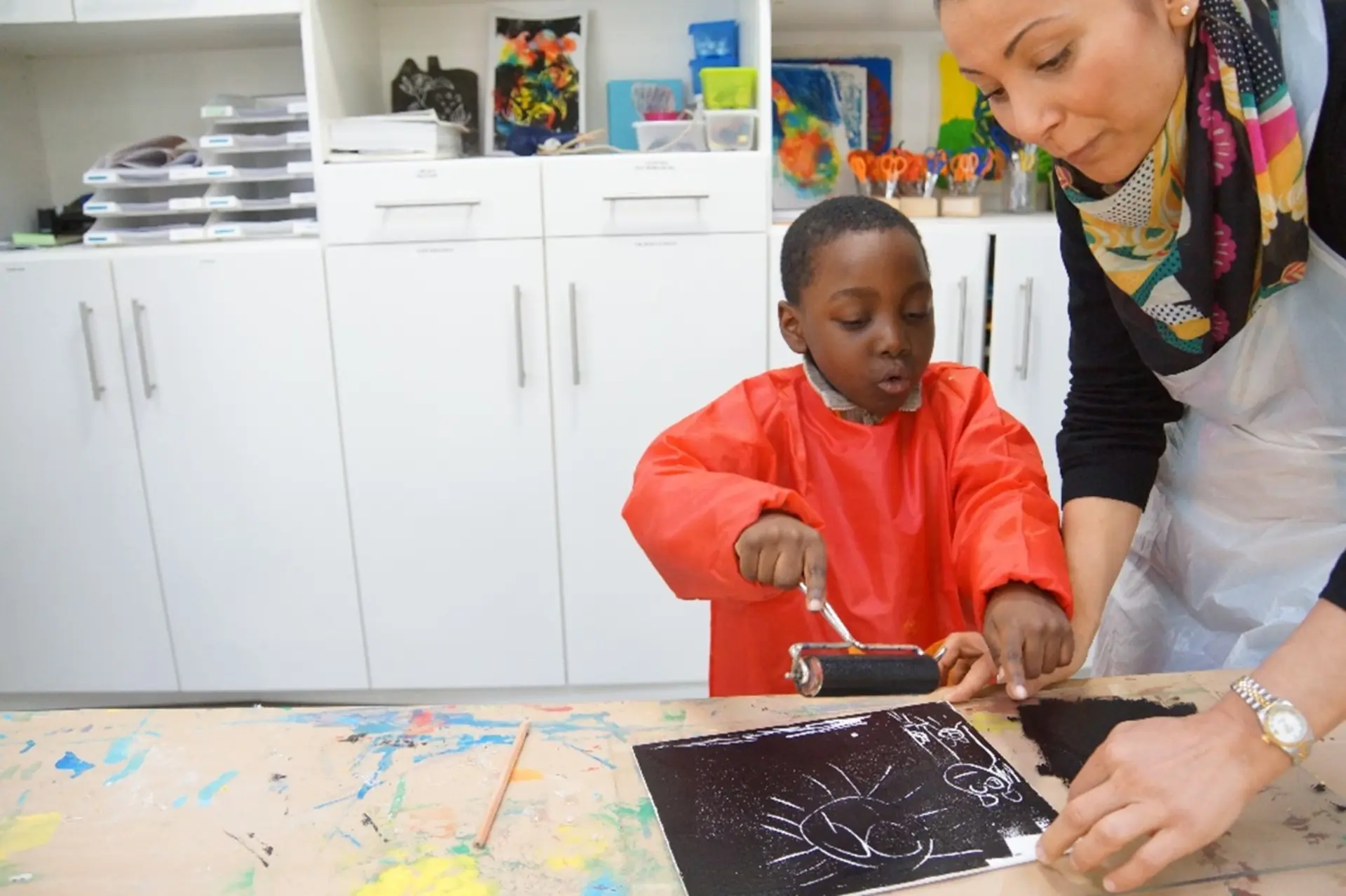Kinder arbeiten mit Ton vor einer bunten Wand