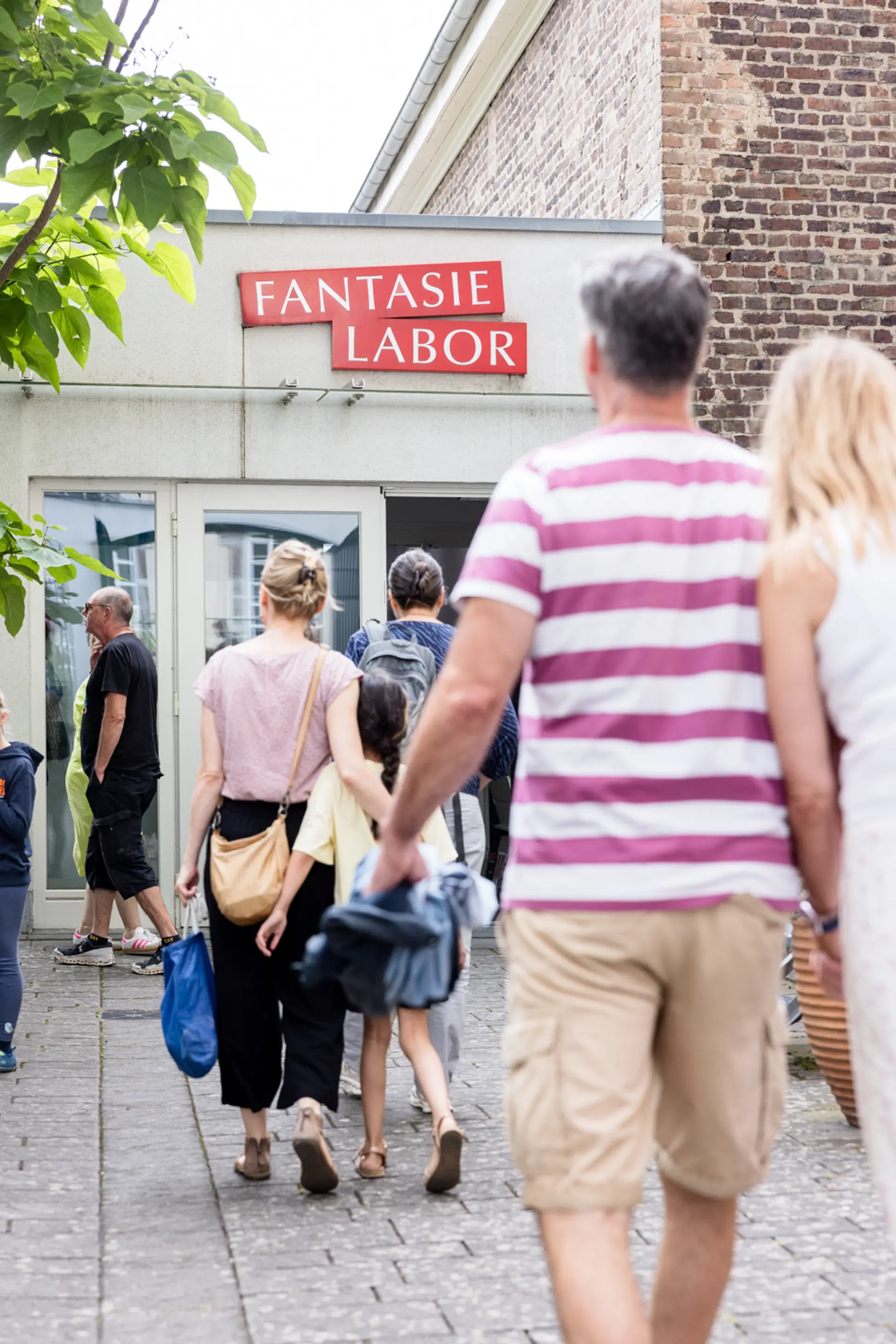 Die Eingangstür zum Fantasie Labor mit Menschen davor