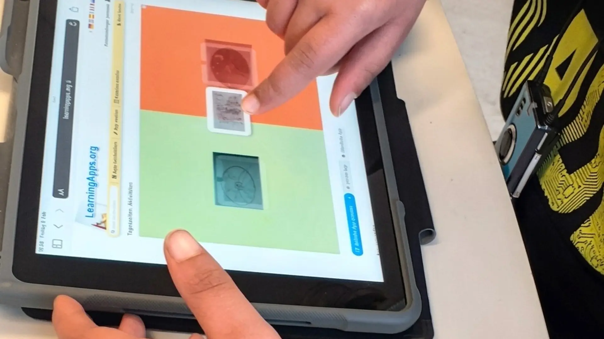 Ein Kind bedient ein IPad mit einer Englisch-App.