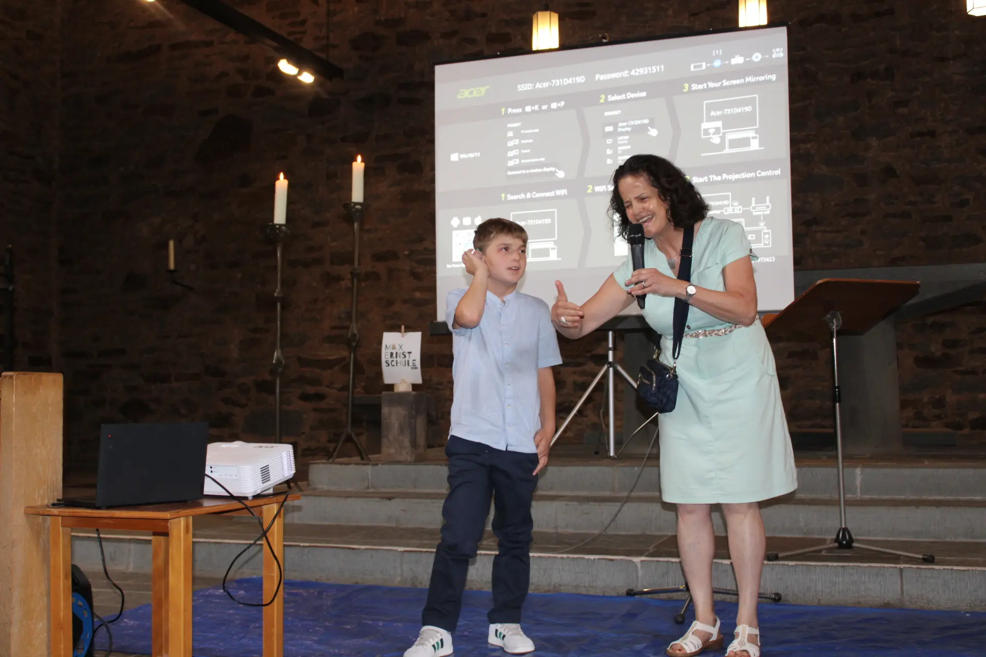 Schüler und Lehrerin stehen gebärdend vorne in der Kirche