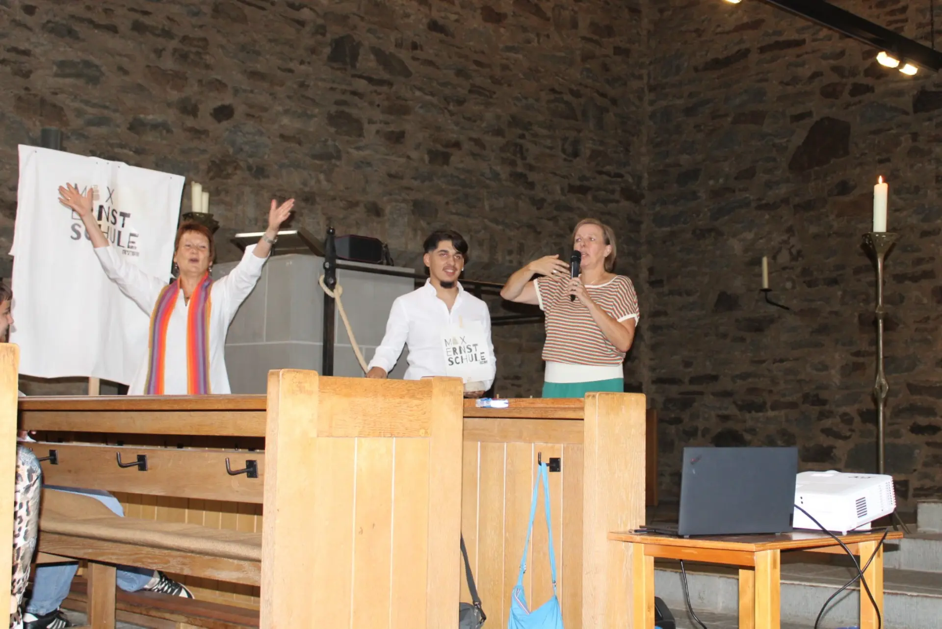 Schüler hält das Tau des MES Segelschiffs Lehrerin und Pastorin heben  Hände zum Leinen los.