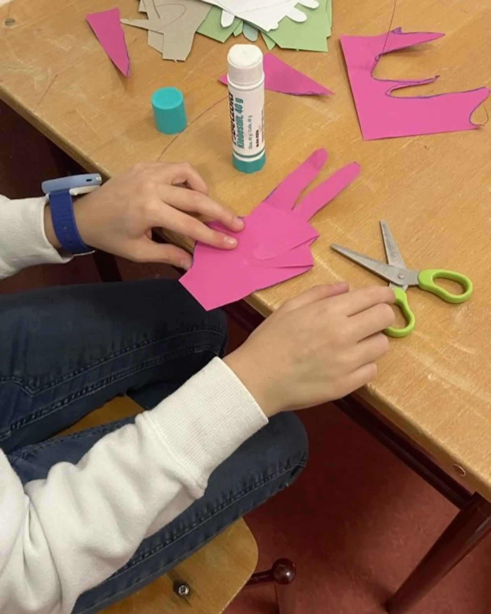 Hände basteln ine pinke Hand aus Tonpapier