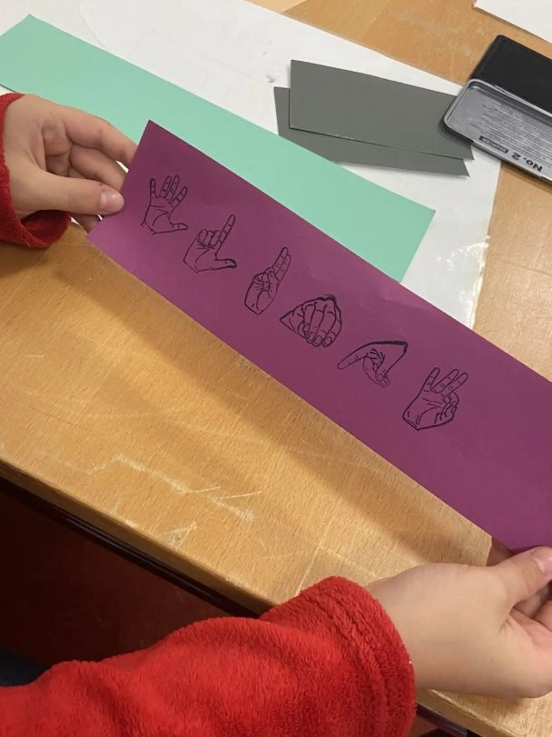 Schlumpf mit Fingeralphabet Stempeln auf pinken Papier