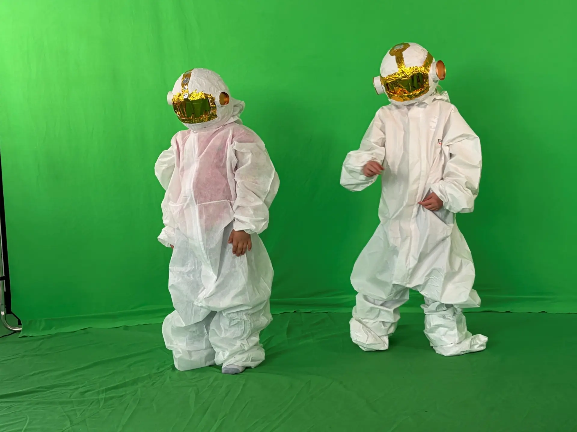 Zwei als Astronauten verkleidete Kinder vor einem Green-Screen