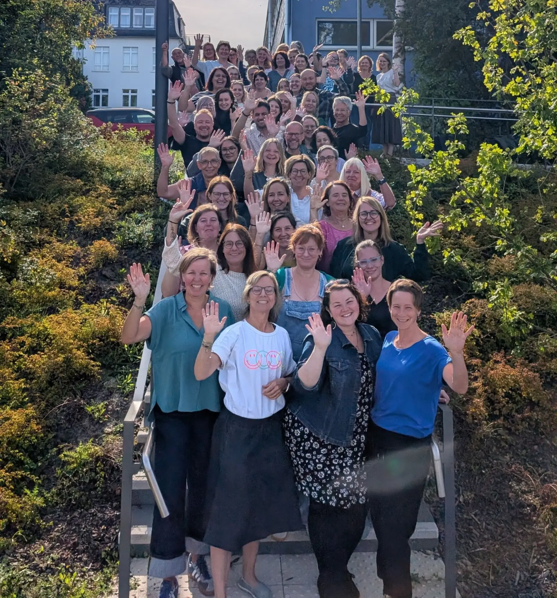 Gruppenfoto der Lehrkräfte auf einer Treppe vor dem Schulgebäude