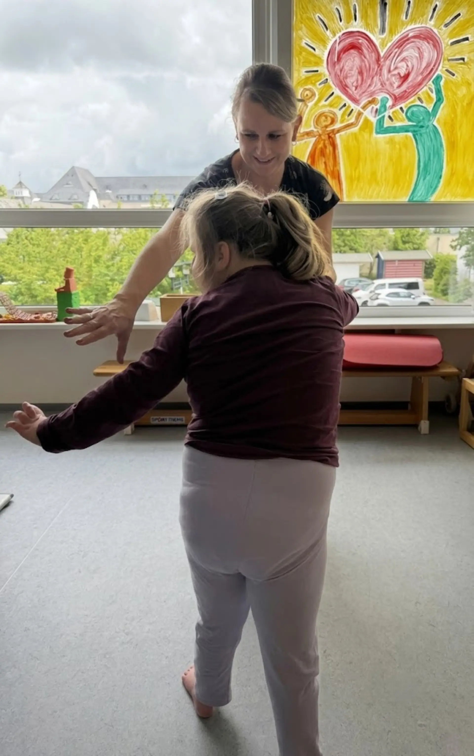 Eine Frau und ein Mädchen stehen sich gegenüber und greifen sich an den Händen