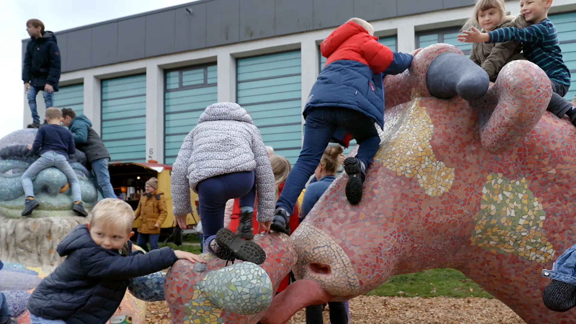 Kinder spielen auf einer Großskulptur.
