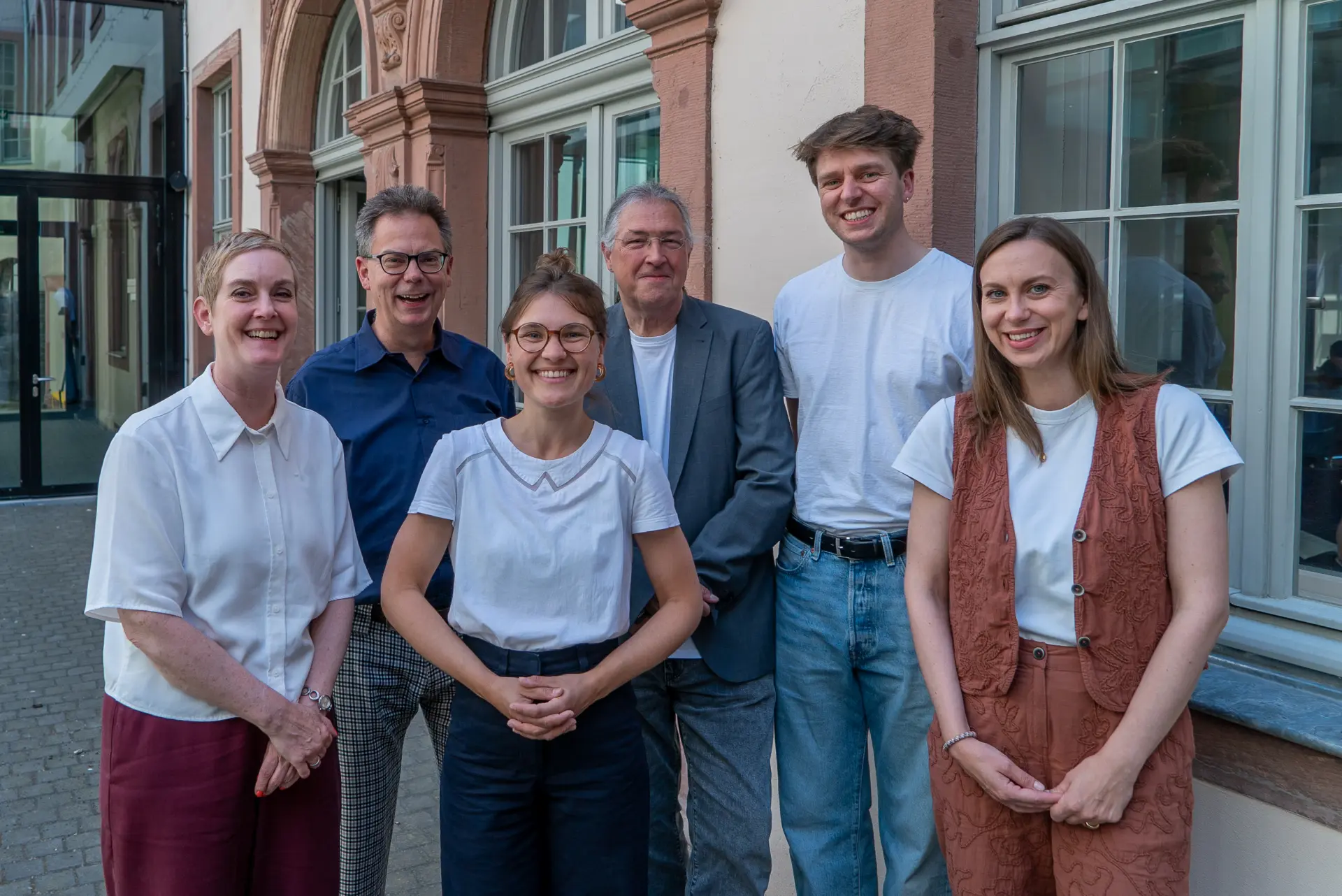 Foto der Redaktionsmitglieder der Zeitschrift "rheinform". Heike Baare, Jens Stöcker, Marianne Miggel, Thilo Martini, Finn Settelmeyer und Annika Flamm (v. l.n. r.) stehen im Historischen Museum Frankfurt und lächeln in die Kamera.