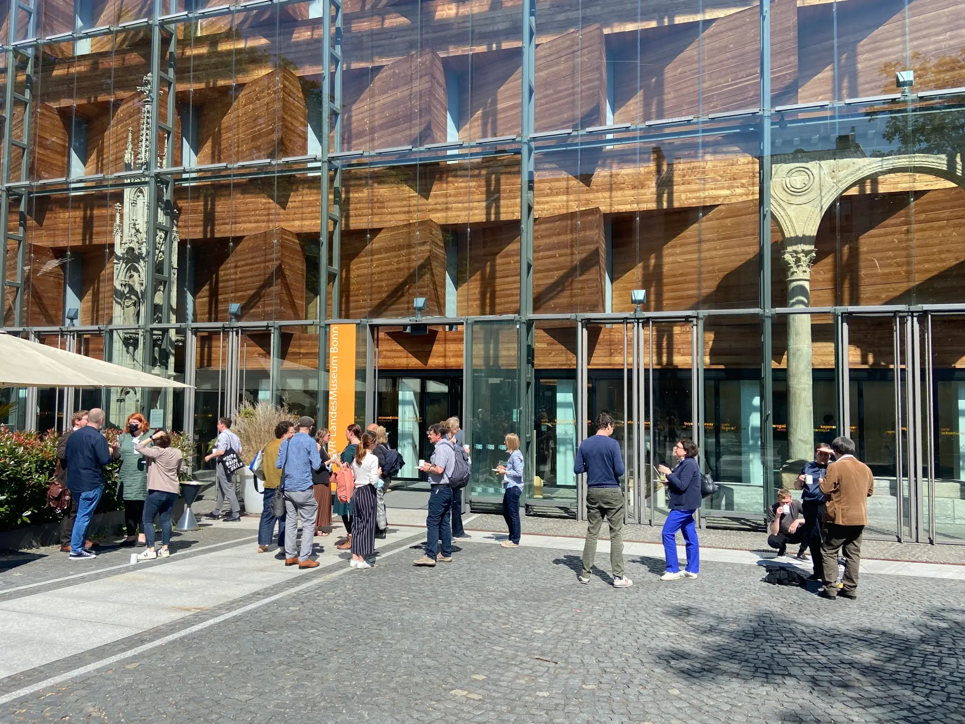 Foto: Vor dem Landesmuseum Bonn stehen Teilnehmende der MAI-Tagung und unterhalten sich.