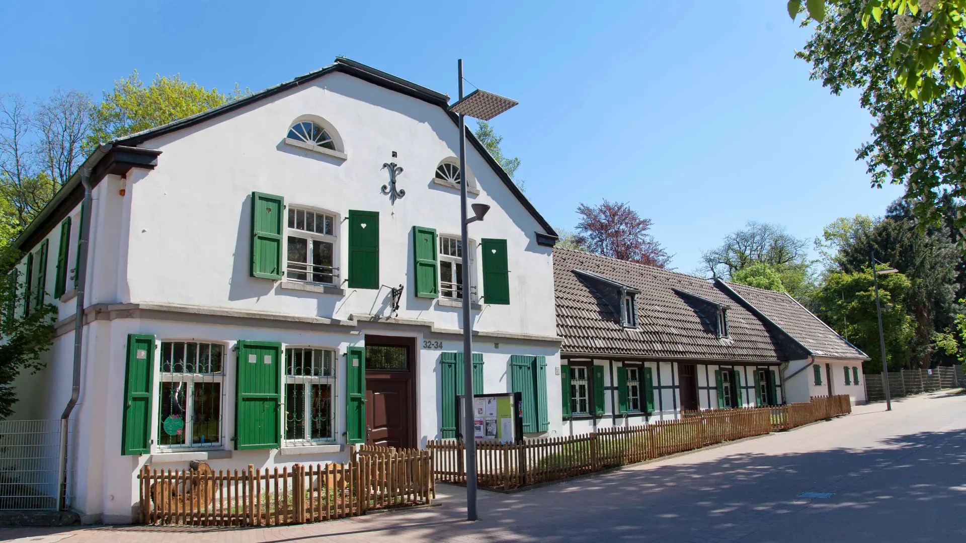 Foto: Ein altes weißes Gebäude mit grünen Fensterläden aus Holz