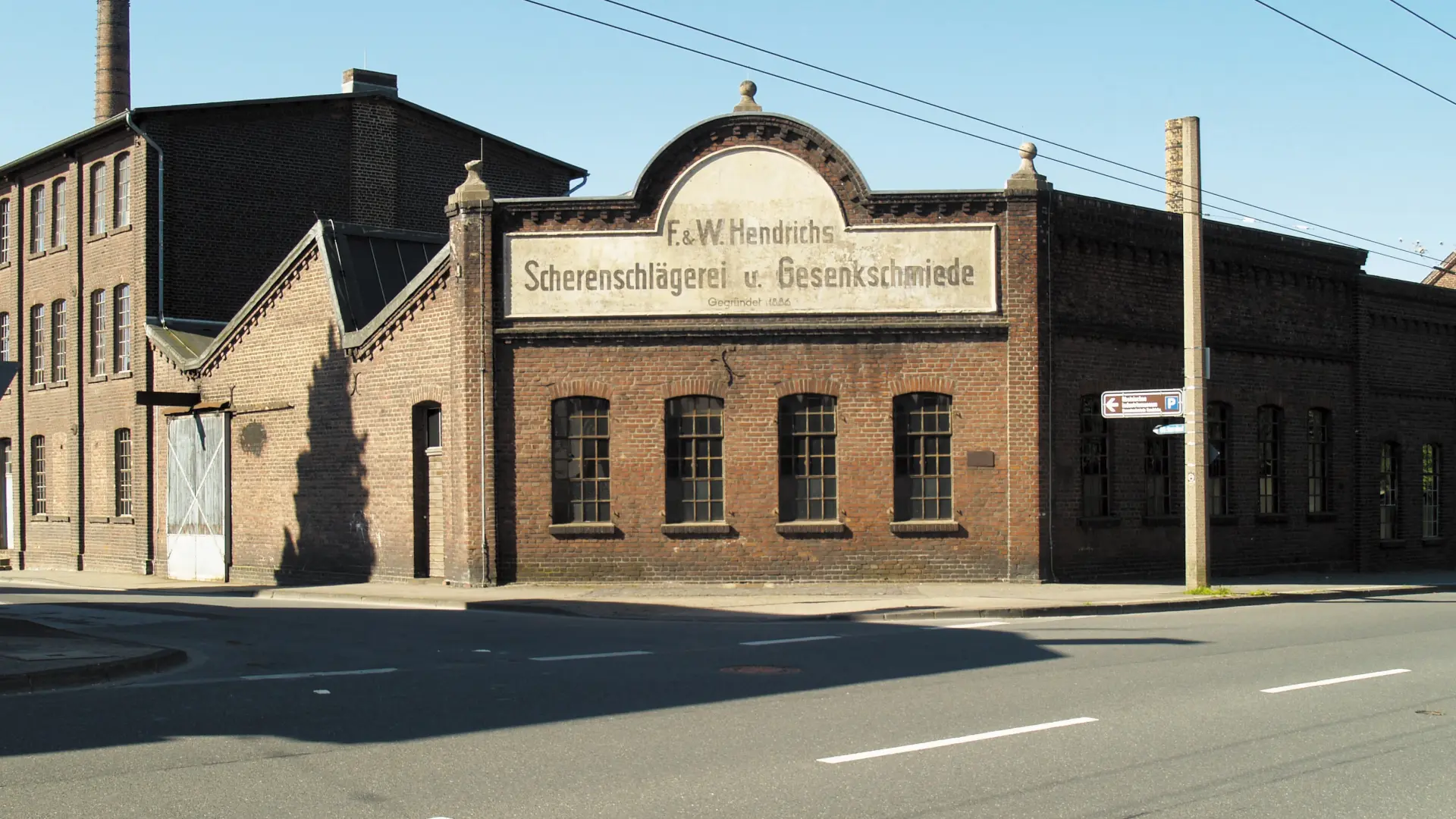 Foto: Fassade einer alten Fabrik mit der Schrift "Scherenschlägerei und Gesenkschmiede"