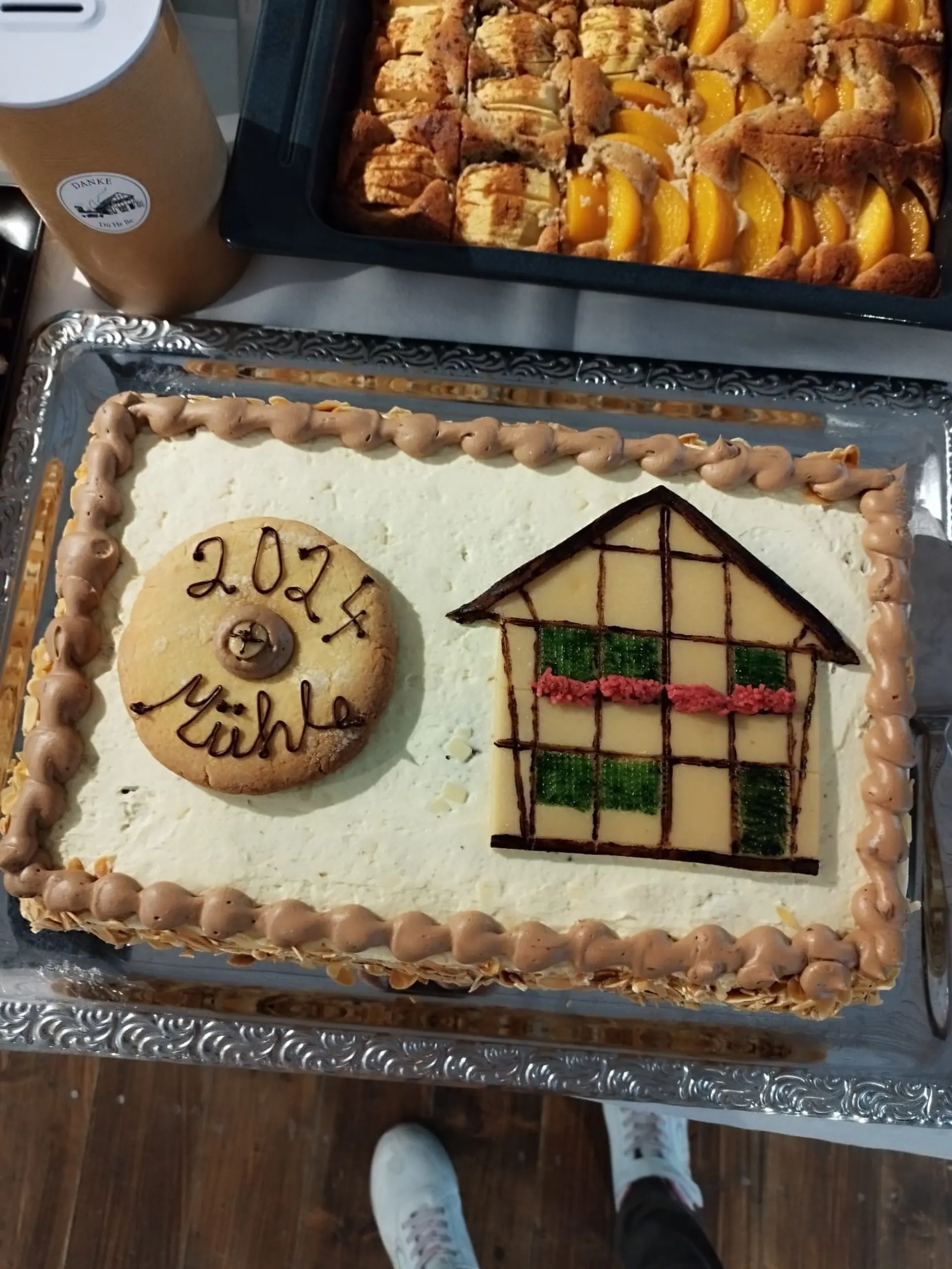 Das Foto zeigt einen Kuchen. Der Kuchen ist mit einem Mühlrad aus Teig verziert. Darauf steht Mühle 2024. Auch ein Fachwerkhaus ist auf dem Kuchen zu sehen. 