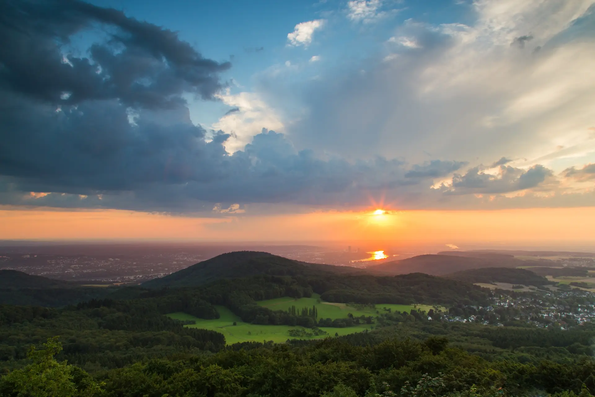 Weiter Blick in ein grüne hügelige Landschaft im Sonnenuntergang