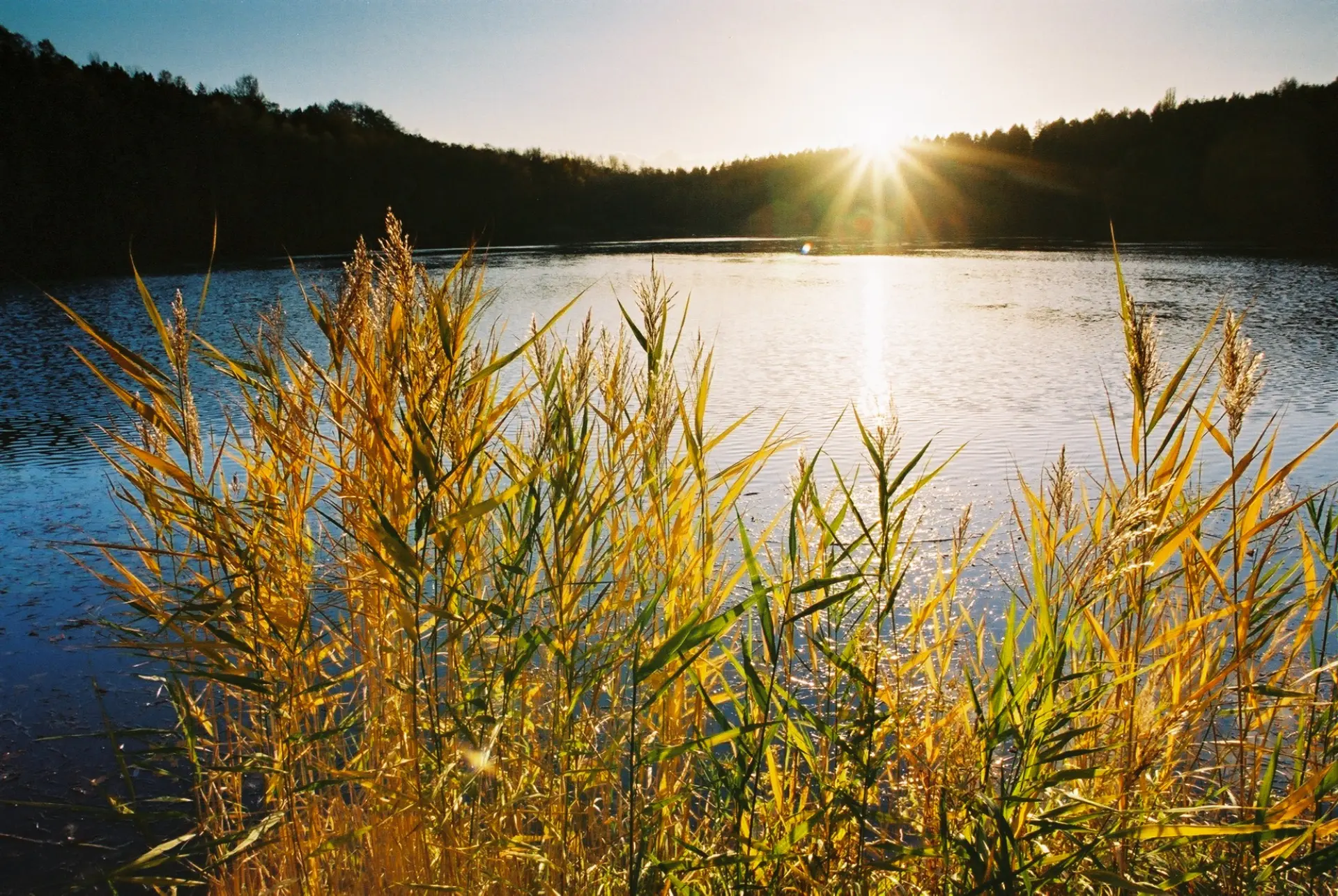 See mit untergehender Sonne im Hintergrund