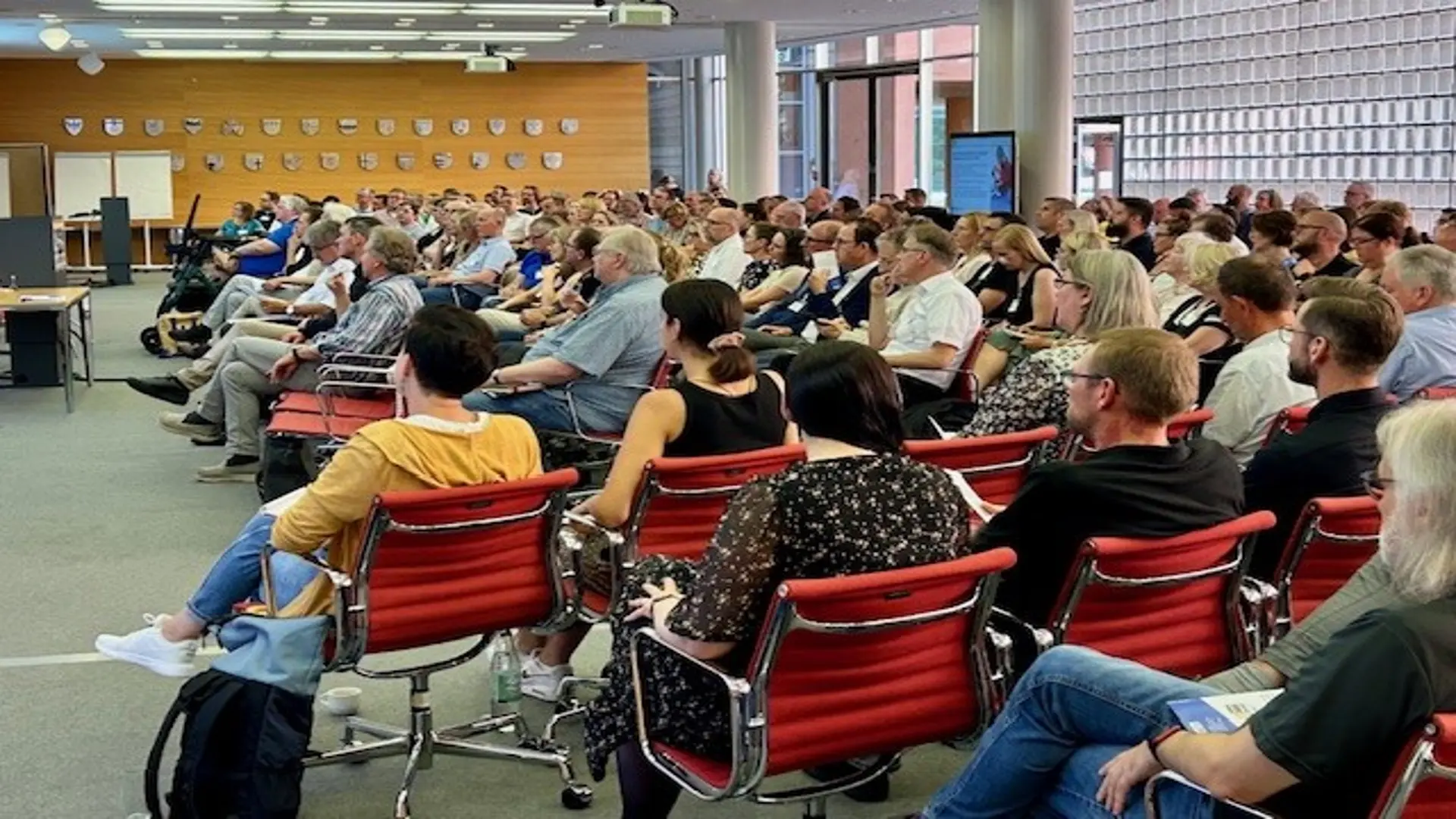 Viele Menschen sitzen in einem Raum.
