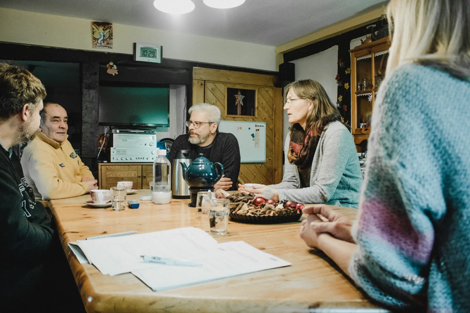Eine Gastfamilie sitzt mit dem Team des LVR am Tisch und unterhält sich.