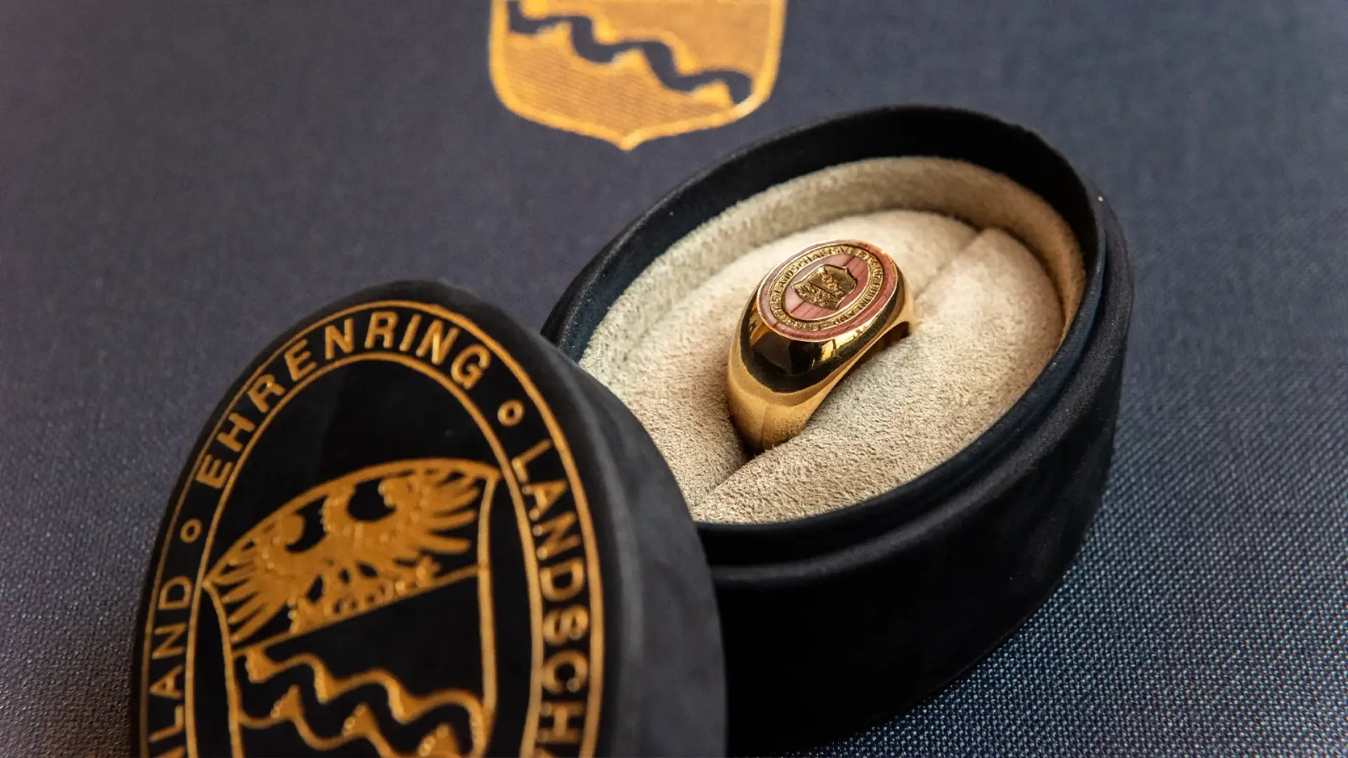 Ein Ring mit einem Wappen in einer Ringdose.