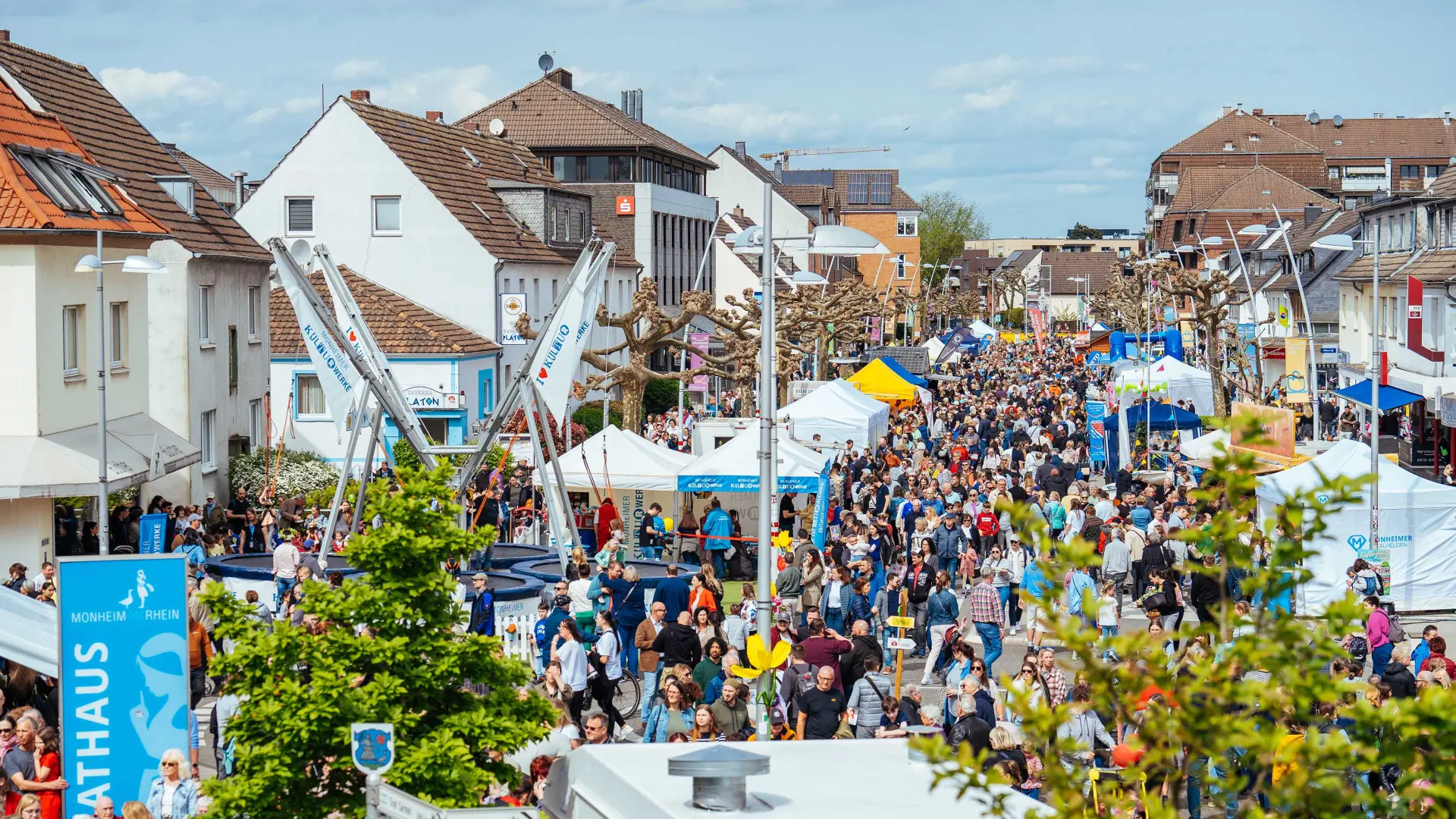 Das Bild zeigt die Krischerstraße in Monheim. Man sieht Tausende Menschen, das Frühlingsfest besuchen. 