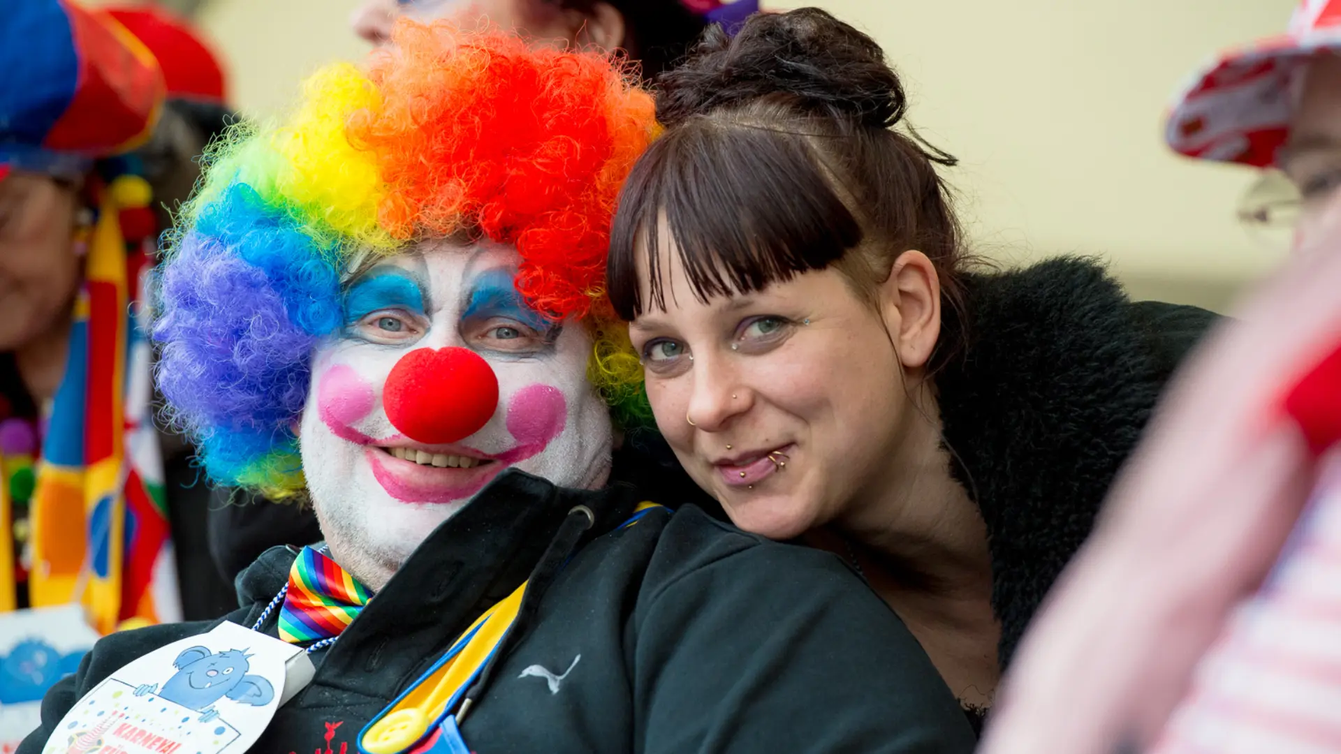 Das Bild zeigt einen Clown und eine unverkleidete Frau. 
