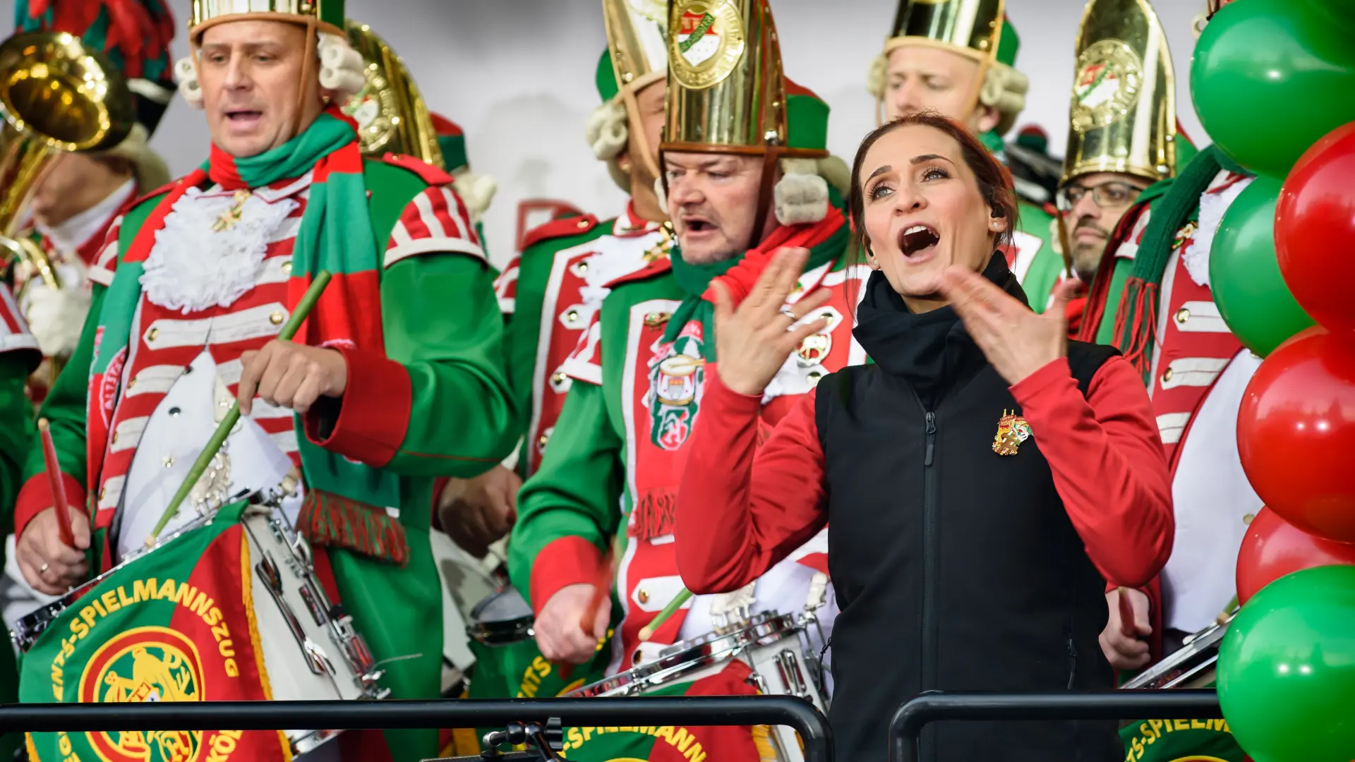 Zwei verkleidete Frauen singen auf dem Heumarkt in Köln vor der Bühne.  