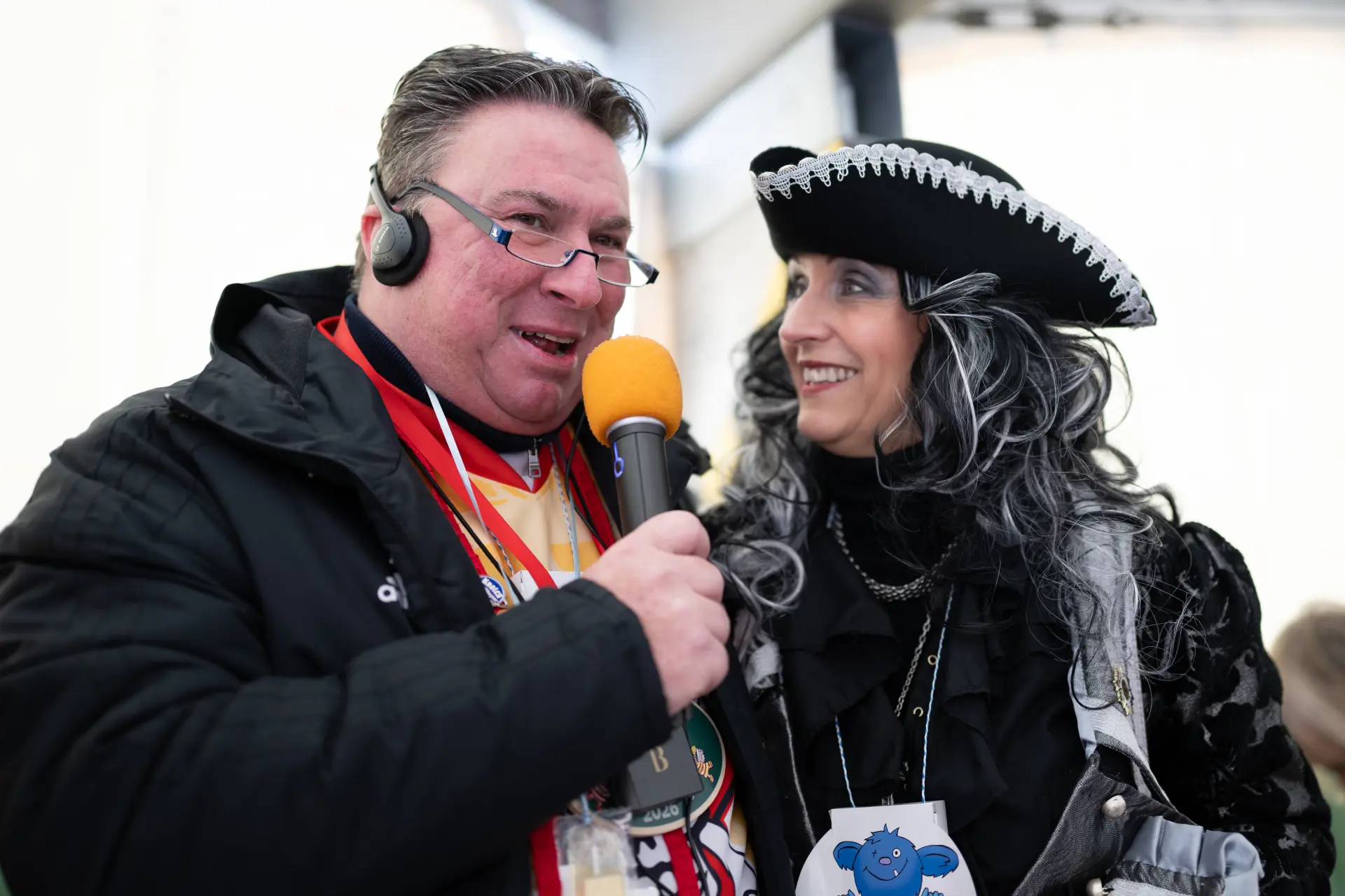 Blindenreporter Frank Breuers erklärt LVR-Direktorin Ulrike Lubek, wie eine Reportage für blinde Menschen funktioniert. Beide sind kostümiert. 