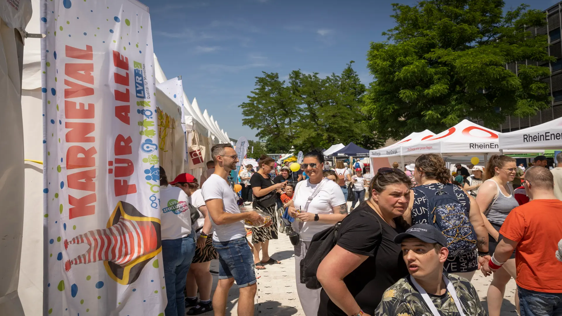 Das Foto zeigt die Ausstellung beim "Tag der Begegnung" am Rhein. Menschen laufen an Ständen entlang. 