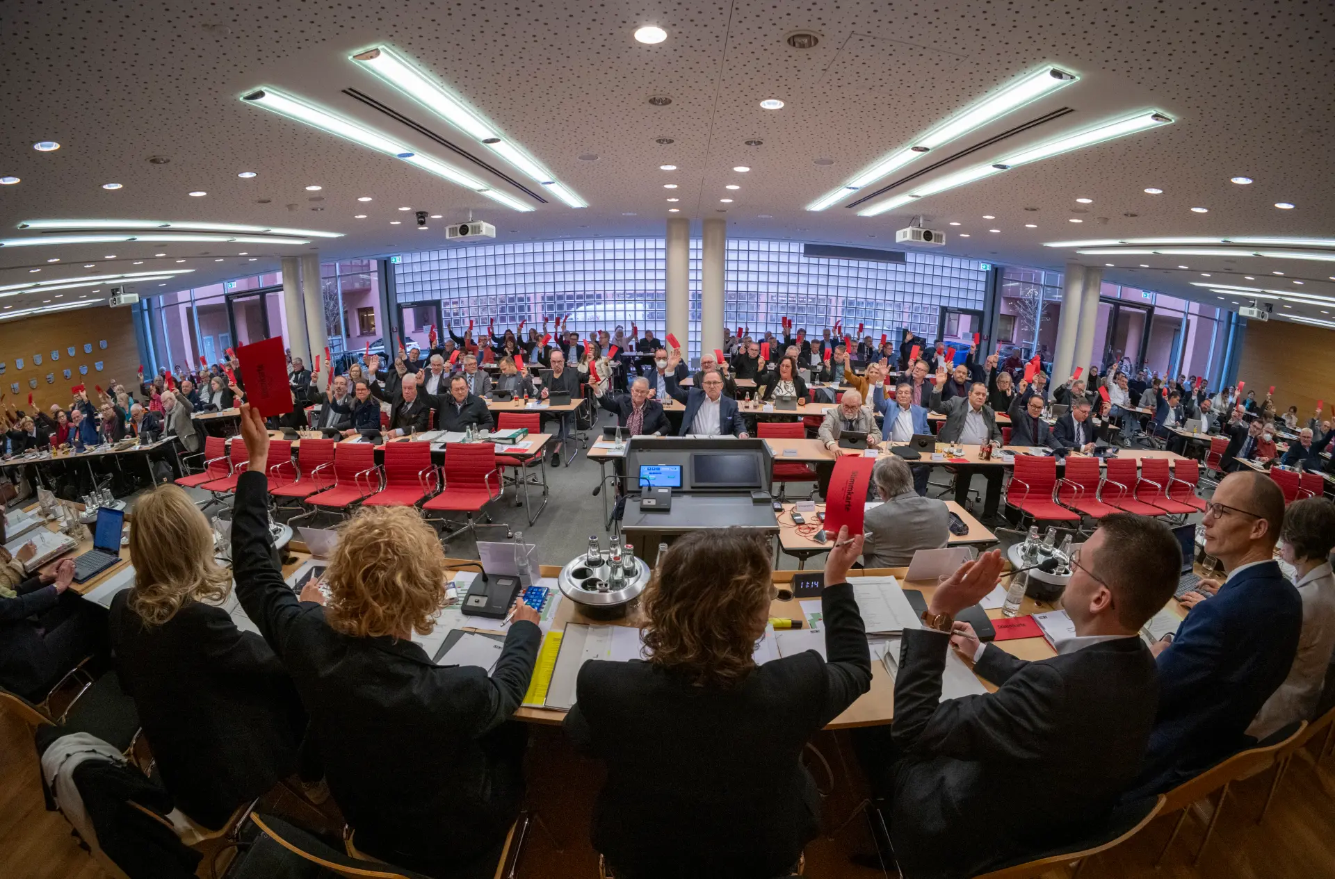 Blick über die Schulter eines Podiums in die Landschaftsversammlung hinein.