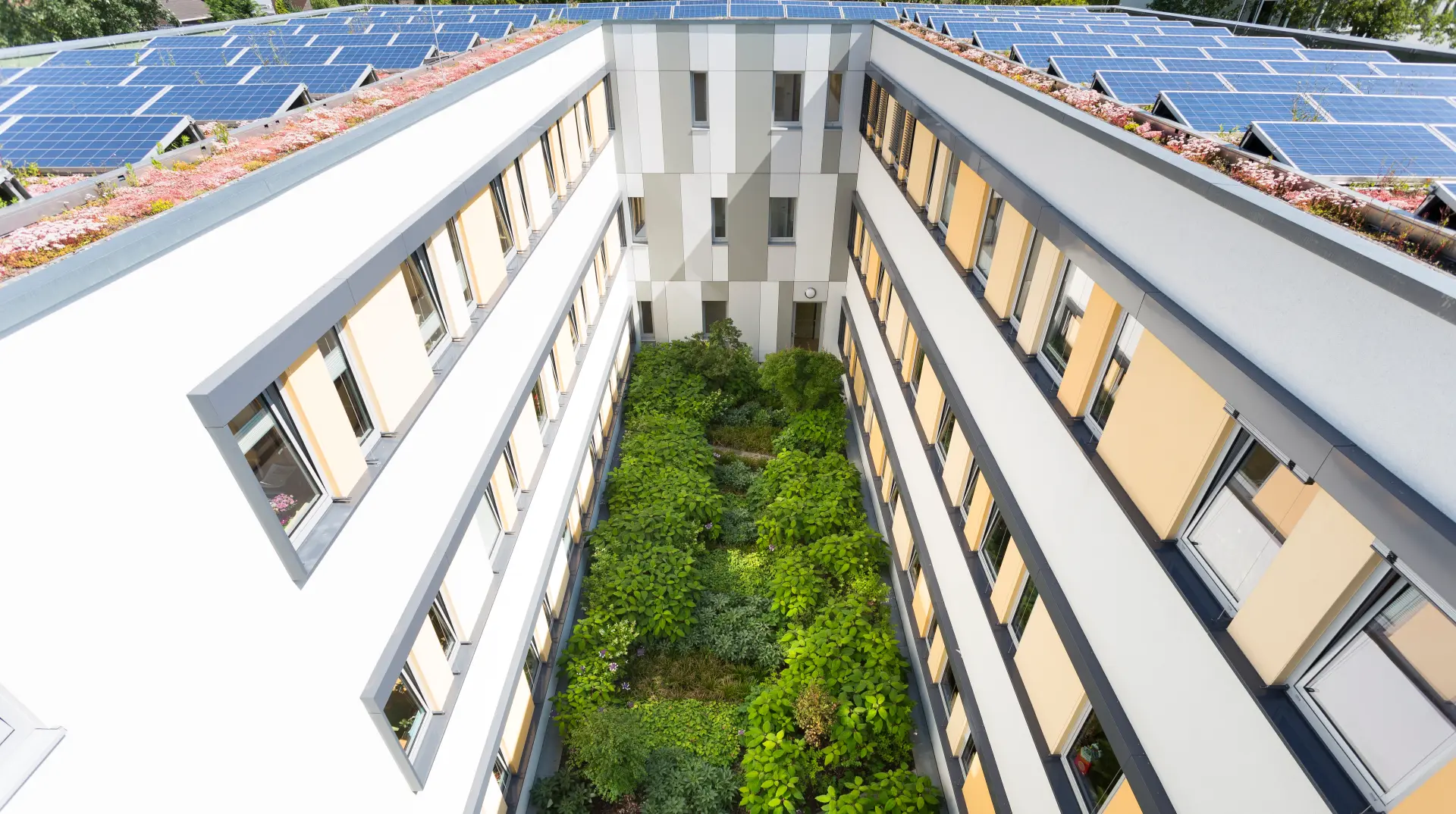 Das Foto zeigt eine Luftaufnahme des Klinikum Essen mit einer PV-Anlage, Dachbegrünung und bepflanztem Innenhof