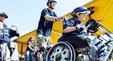 Rollstuhlfahrer und Inlineskater fahren gemeinsam