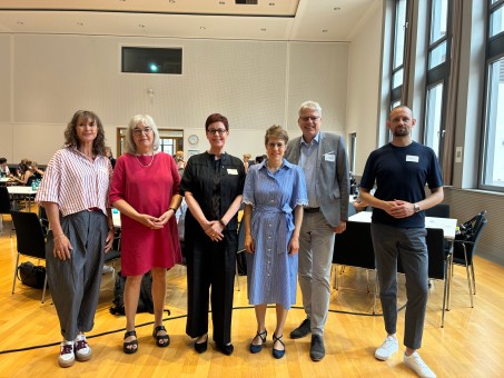 Eine Gruppe steht in einem Konferenzraum.