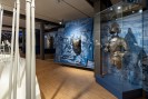 Blick in die Ausstellung. In Vitrinen sind Rüstungen ausgestellt.