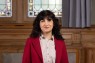 Eine Frau mit schwarzen Haaren und rotem Blazer