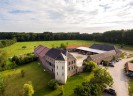 Luftaufnahme der viereckigen, burgähnlichen Hofanlage von Haus Bürgel, die mitten auf einer großen Wiese steht.
