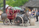 Besucher*innen schauen auf ein historisches Fahrzeug, das im Freien ausgestellt ist.