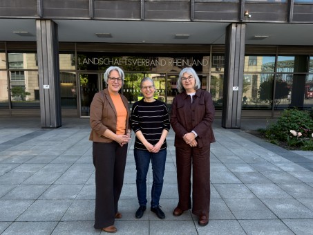 Drei Frauen vor einer Glast&uuml;r mit der Aufschrift Landschaftsverband Rheinland