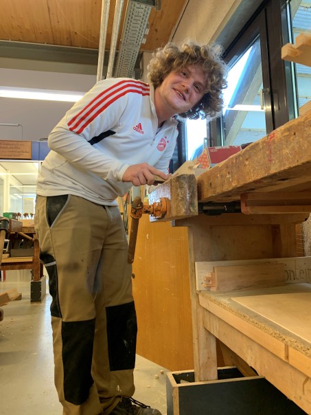 Ein junger Mann arbeitet an einer Werkbank