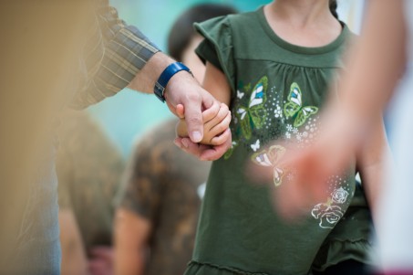 Ein Erwachsener hält ein Kind an der Hand