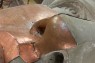 Nahaufnahme eines Gesichts aus Stein und Kupfer. 