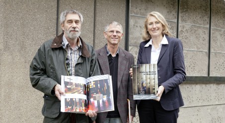 zwei Männer und eine Frau, die Bücher in der Hand halten