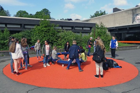 Kinder spielen an einem Gerät auf dem Schulhof