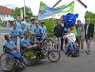 Gruppe von Kindern in blauen T-Shirts mit Fahrrädern und Handbikes
