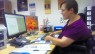 Frau im Rollstuhl vor Computer in Büro.