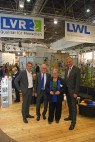 Vier Personen vor Messestand