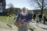 Frau in Kostüm mit Korb voll Brezeln in der Hand