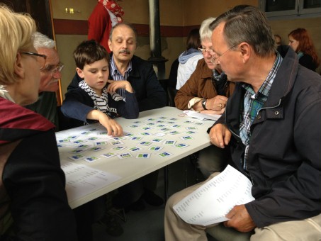Erwachsene und Kinder spielen Memory.